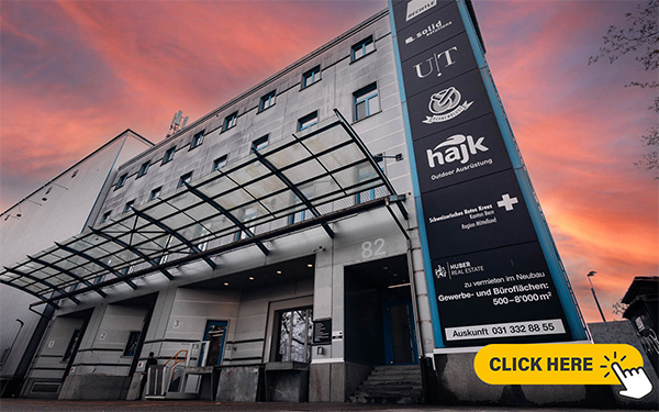 Vue de l’entrée d’un bâtiment industriel, avec un escalier et plusieurs quais de chargement couverts.