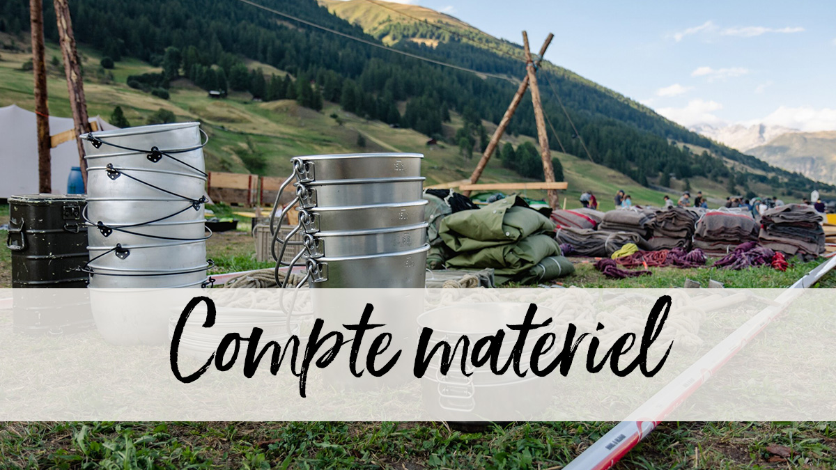 Vue rapprochée de matériel scout entreposé dans un champ ouvert au cœur d'une vallée alpine suisse.