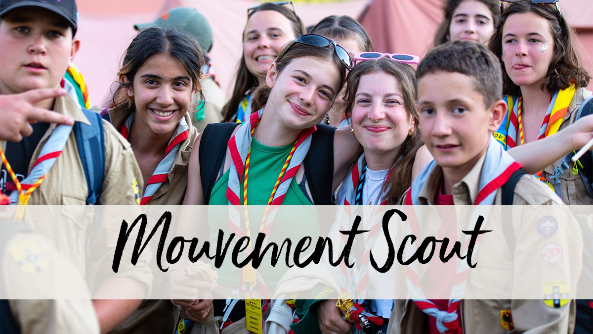 Gros plan d'un groupe de jeunes scouts souriant face à la caméra.