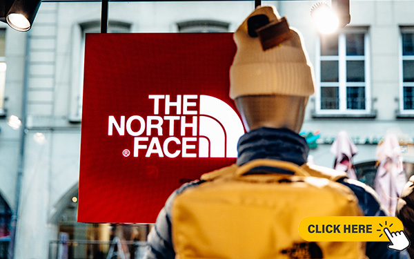 Vue de la vitrine du magasin The North Face à Berne, avec des mannequins en vêtements outdoor.