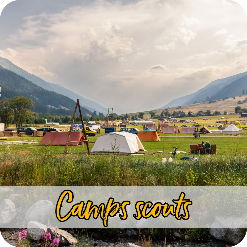 Vue sur le camp de tentes d’un camp scout dans une grande prairie.