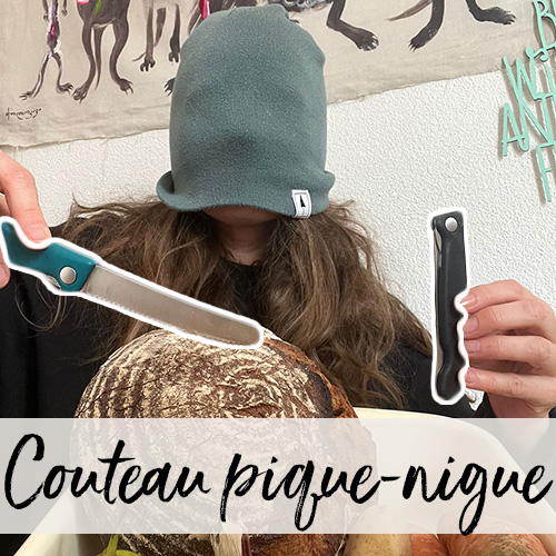 Une femme, son bonnet en laine tiré sur les yeux, tient deux couteaux suisses au-dessus d’un pain.